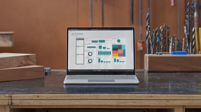 Front view of Surface Laptop Go 3 on a work bench showing a power app.