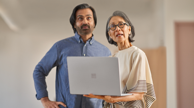 Colleagues collaborating over a Surface laptop.