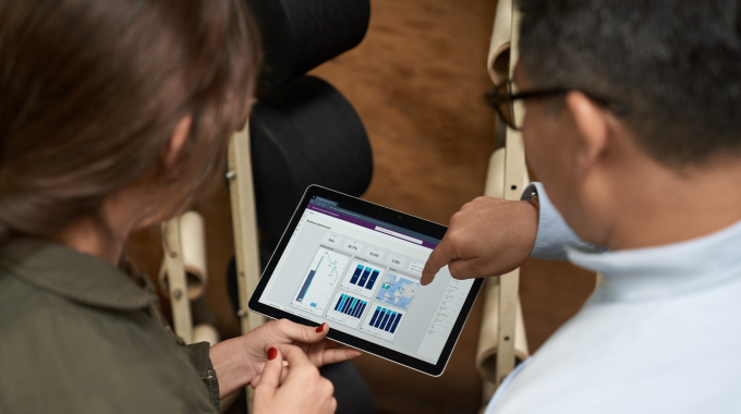 CEO and COO of a textile manufacturing plant working together to analyze data and manage inventory on the warehouse floor.